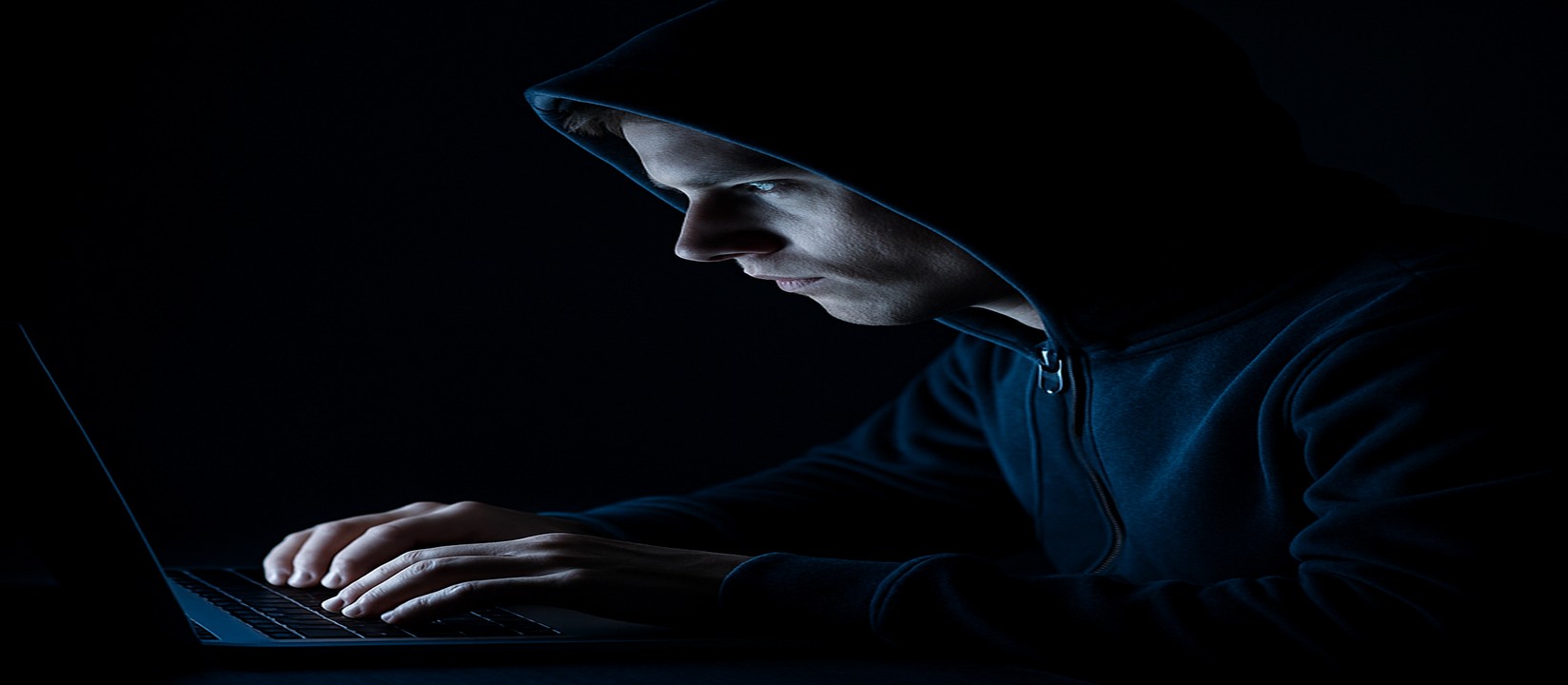 একজন ব্যক্তি অন্ধকারে ল্যাপটপের সামনে বসলেন, মনোযোগী চেহারা নিয়ে ace67 ওয়েবসাইটে অনলাইন গেমিং করছেন